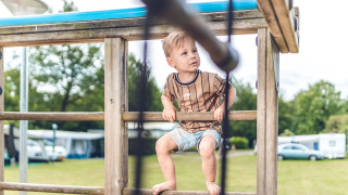 Niño jugando en un parque infantil en Veluwepark de Bosgraaf, parque vacacional en Gelderland, Países Bajos.