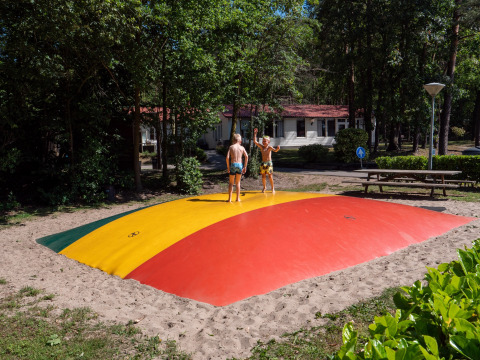 Two children play on a colorful jumping pillow at Recreatiepark de Wrange holiday park in Gelderland.