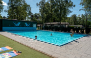 Niños jugando en la piscina exterior de Recreatiepark de Wrange en Gelderland, Países Bajos.
