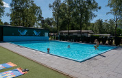 Udendørs swimmingpool med børn, der leger, ved Recreatiepark de Wrange i Gelderland, Holland.