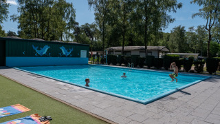 Kinder spielen im Freiluft-Schwimmbad von Recreatiepark de Wrange, Gelderland, Niederlande.