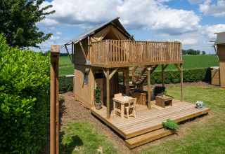 Safaritent met sanitaire voorzieningen bij Camping Mareveld in Nederland, met houten terras en balkon.