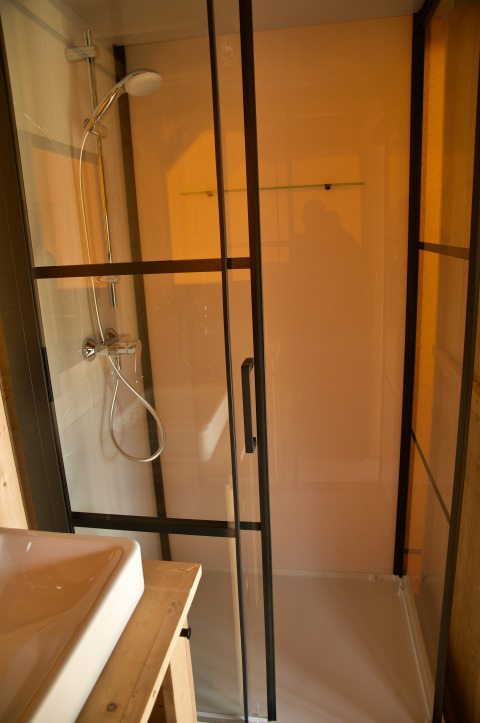 Ducha y lavabo en tienda safari con instalaciones sanitarias privadas en Camping Mareveld, Países Bajos.
