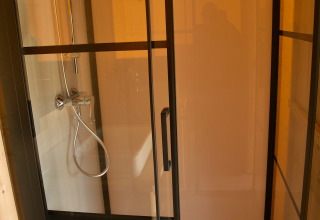 Ducha y lavabo en tienda safari con instalaciones sanitarias privadas en Camping Mareveld, Países Bajos.