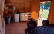 Interior de una tienda safari con cocina y mesa en Recreatiepark de Wrange, Países Bajos, con vista exterior.