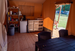 Interno di una tenda safari con cucina e tavolo al Recreatiepark de Wrange nei Paesi Bassi, vista esterna.