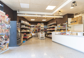 A bright supermarket at Camping del Mar, Catalonia, Spain, with shelves stocked with groceries.