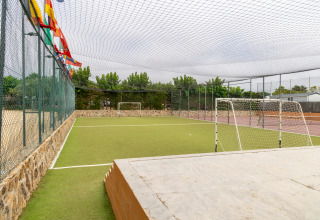 Kleine Kunstrasen-Fußballplatz mit Toren und Fangnetz im Camping del Mar Ferienpark in Katalonien, Spanien.