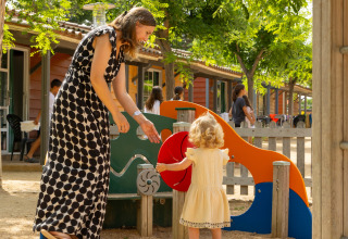 Donna e bambina giocano insieme nell’area giochi colorata al Camping del Mar, Catalogna, Spagna.