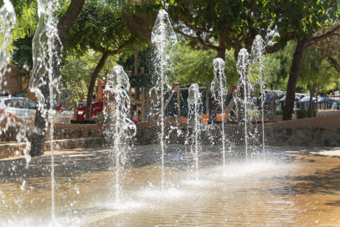 Fonteinstralen in een schaduwrijk stuk aan Camping del Mar vakantiepark, Catalonië, Spanje.