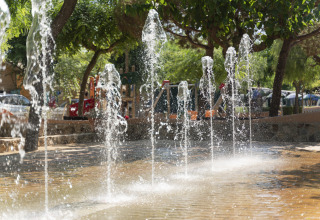 Fonteinstralen in een schaduwrijk stuk aan Camping del Mar vakantiepark, Catalonië, Spanje.