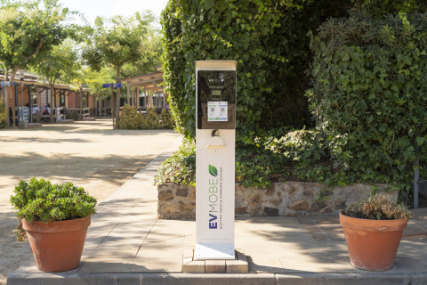 Elektroauto-Ladestation im Ferienpark Camping del Mar, umgeben von Grün, in Katalonien, Spanien.