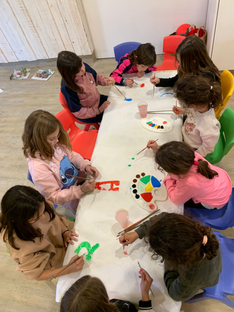 Niños pintando juntos en una mesa en Camping del Mar, un parque vacacional en Cataluña, España.