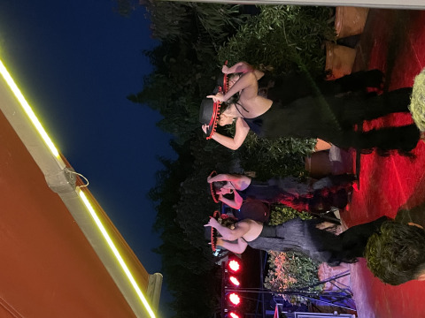 Danseuses portant des chapeaux sur scène en plein air le soir au Camping del Mar en Catalogne, Espagne.