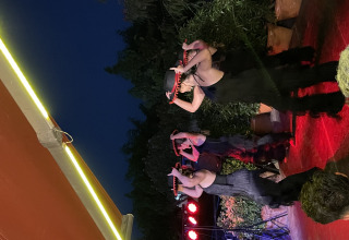 Dansere optræder med hatte på en udendørs scene om aftenen ved Camping del Mar i Catalonien, Spanien.