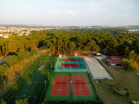 Luchtfoto van sportvelden in Bi Village vakantiepark, Istrië, Kroatië met tennisbanen en groene bomen.