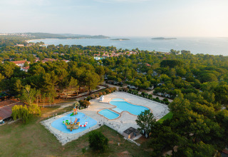 Aerial view of Bi Village holiday park in Istria, Croatia, showing pools, green forests, and sea scenery.