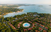Luftfoto af Bi Village feriepark i Istrien, Kroatien, med pool, hytter og udsigt over kysten og marinaen.
