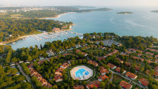 Luchtfoto van vakantiepark Bi Village in Istrië, Kroatië, met zwembad, huisjes en uitzicht op de kustlijn.