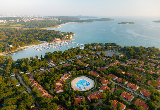 Luchtfoto van vakantiepark Bi Village in Istrië, Kroatië, met zwembad, huisjes en uitzicht op de kustlijn.