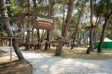 Entrada al Jangalooz Adventure Park en Bi Village, un parque de vacaciones en Istria, Croacia, con circuitos elevados en los árboles.