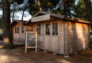 Træhytter ved Bi Village feriepark i Istrien, Kroatien, omgivet af træer og skyggefulde omgivelser.