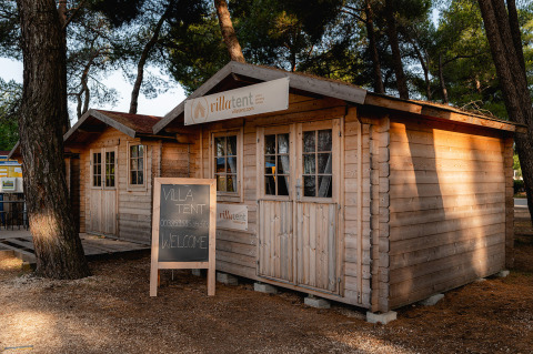 Houten huisjes bij Bi Village vakantiepark in Istrië, Kroatië, omgeven door pijnbomen en natuur.