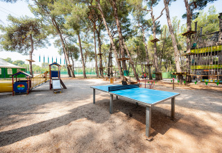 Speeltuin en tafeltennistafel in een schaduwrijk bos bij Bi Village vakantiepark in Istrië, Kroatië.
