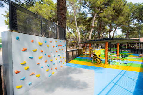 Parco giochi colorato con parete da arrampicata e percorso a ostacoli al Bi Village in Istria, Croazia.