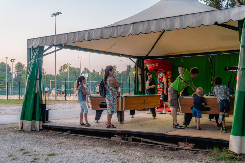 Persone che giocano a calcio balilla sotto una tenda al villaggio turistico Bi Village in Istria, Croazia.