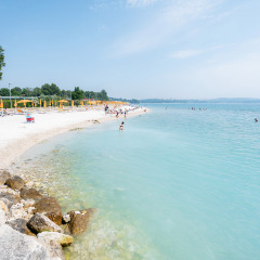 Playa de aguas cristalinas y sombrillas en Bi Village, un parque vacacional en Istria, Croacia.