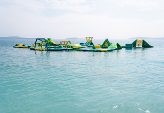 Opblaasbaar waterpark drijvend in zee aan Bi Village vakantiepark in Istrië, Kroatië, op een zonnige dag.