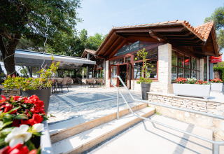Buitenterras van een restaurant in Bi Village vakantiepark, Istrië, Kroatië, omgeven door groene bomen.