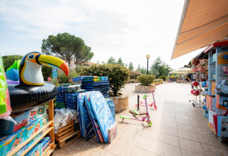 Speelgoed en zwembadspeelgoed buiten een winkel in Bi Village vakantiepark, Istrië, Kroatië op een zonnige dag.