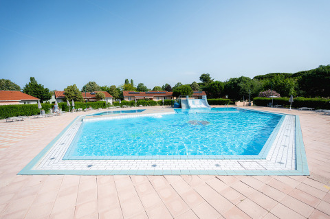 Outdoor swimming pool with a slide at Bi Village holiday park in Istria, Croatia, on a sunny day.