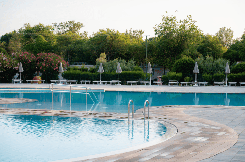 Piscina all’aperto con lettini e ombrelloni al villaggio turistico Bi Village, Istria, Croazia.