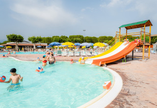 Gezinnen ontspannen aan het zwembad met waterglijbaan en ligstoelen in Campeggio del Garda, Veneto, Italië.