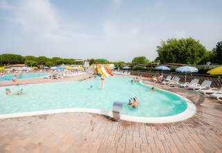 Family-friendly swimming pool area with waterslides, sun loungers and umbrellas at Campeggio del Garda in Veneto.