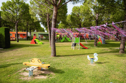 Spielplatz im Campeggio del Garda mit Rutschen und bunten Ferienhäusern im Grünen, Veneto, Italien.
