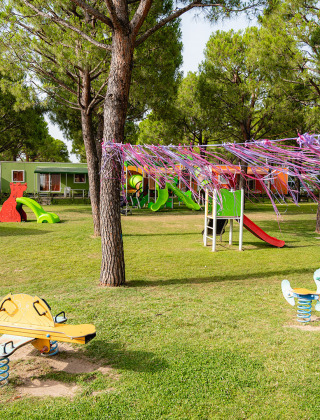 Parque infantil en Campeggio del Garda con toboganes, columpios y bungalows coloridos en Veneto, Italia.
