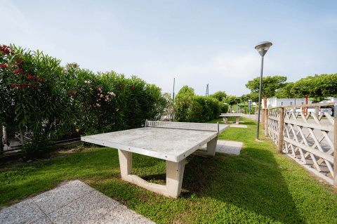 Udendørs bordtennisbord i grøn omgivelser ved Campeggio del Garda, en feriepark i Veneto, Italien.