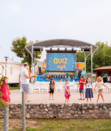 Niños juegan frente a un escenario de ‘Quiz Night’ en Campeggio del Garda, un parque vacacional en Véneto, Italia.