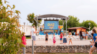 Niños juegan frente a un escenario de ‘Quiz Night’ en Campeggio del Garda, un parque vacacional en Véneto, Italia.