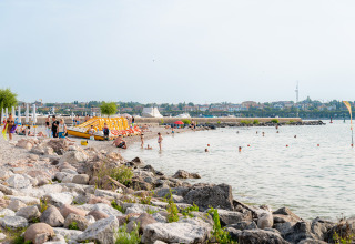 Strandtafereel bij Campeggio del Garda, Veneto, Italië, met mensen die zwemmen en ontspannen.