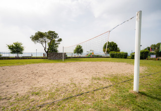 Sand-Volleyballfeld im Campeggio del Garda in Venetien, Italien, mit grünem Rasen und Netz.