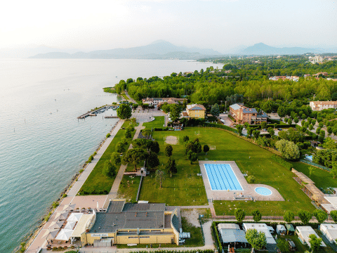 Vue aérienne du parc de vacances Campeggio del Garda en Vénétie, Italie, avec piscine, lac et espaces verts.
