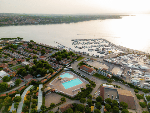 Aerial view of Campeggio del Garda holiday park in Veneto, Italy, showing the pool, cabins and marina.