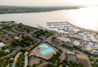 Vista aerea del Campeggio del Garda a Veneto, Italia, con piscina, bungalow e porto turistico sul lago.