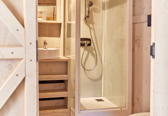 Bagno nella tenda safari Villatent Outback al Campeggio del Garda in Italia con doccia e wc moderno.