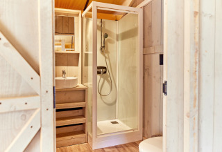 Moderne badkamer met douche en wastafel in een safaritent op Campeggio del Garda, Italië, houtaccenten.